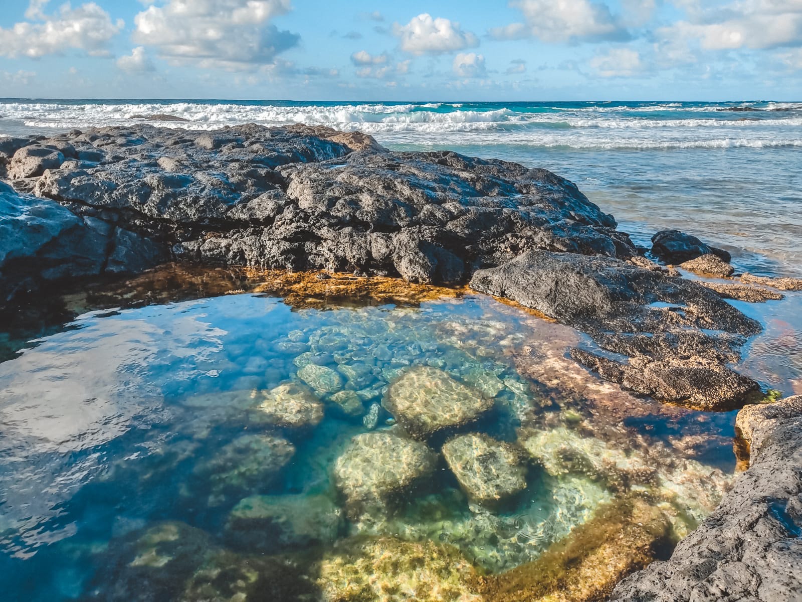 Pozze d'acqua limpida tra le rocce laviche